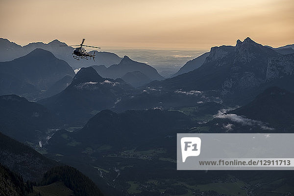 Austria  Salzburg State  Loferer Steinberge  helicopter in mountainscape at twilight