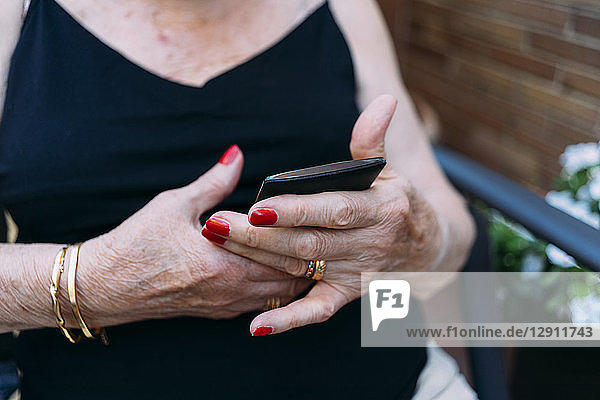 Hands of senior woman using smartphone
