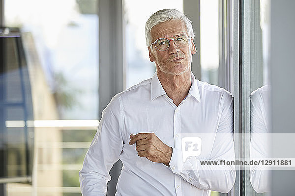 Businessman standing by window  contemplating