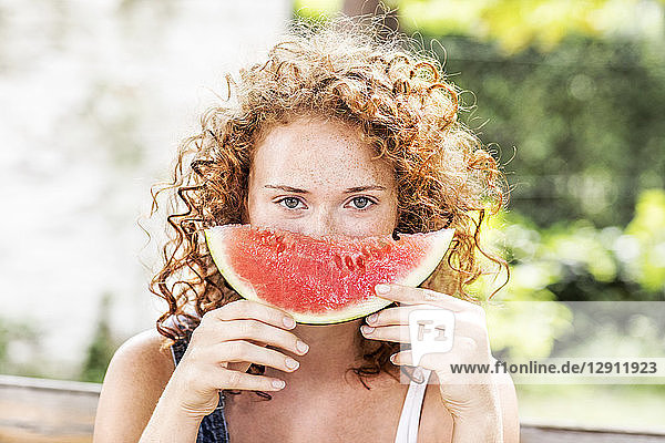 Portrait of redheaded young woman with watermelon