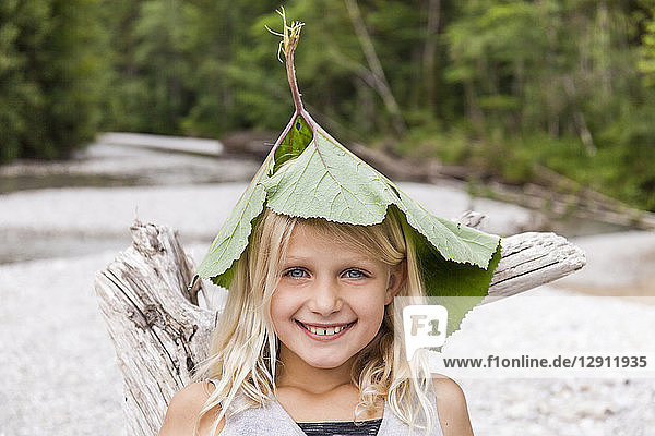 Portrait of happy girl at the riverside wearing leaves on her head