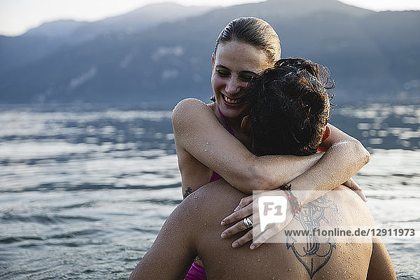 Happy young couple hugging in a lake