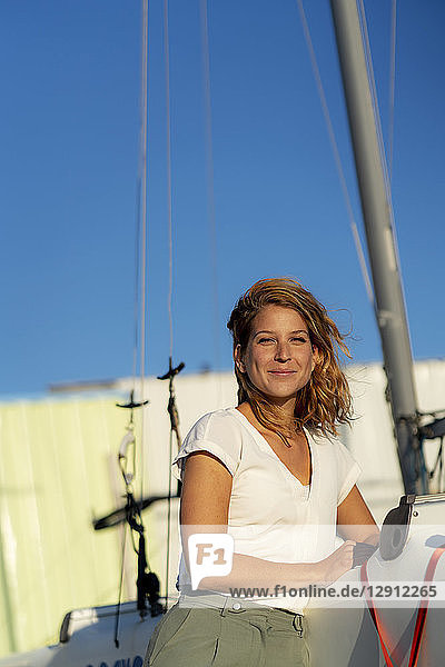 Portrait of a beautiful woman standing by a boat in summer