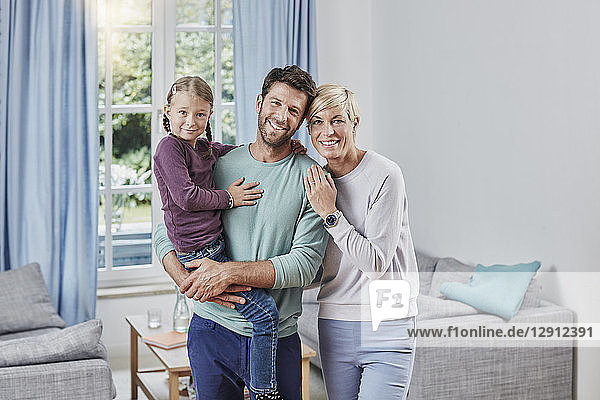 Portrait of happy parents with daughter at home