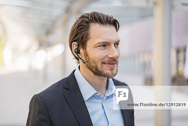 Portrait of smiling businessman wearing headset outdoors