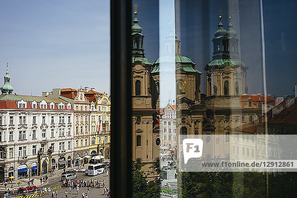 Czechia  Prague  view to Old Town Square and St. Nicholas Church reflecting on windowpane