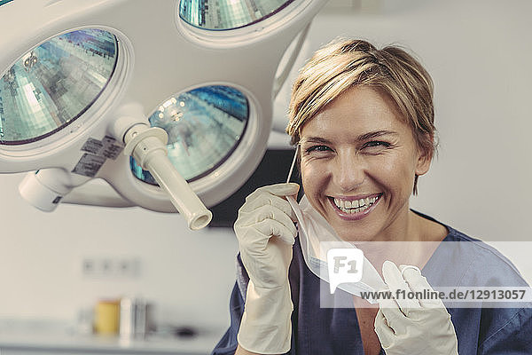 Dental surgeon removing surgical mask  portrait