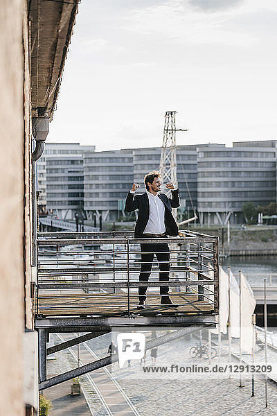 Businessman standing on balcony  flexing muscles