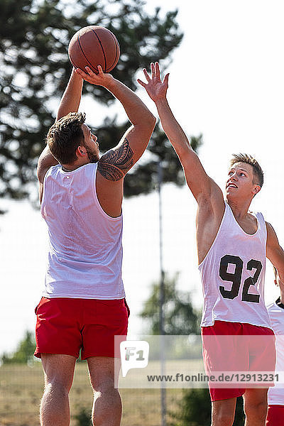 Two young men playing basketball