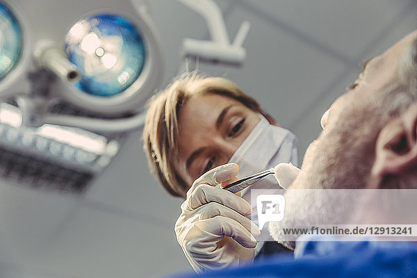 Dental surgeon during surgical procedure on a patient