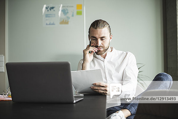 Young businessman working at desk in office