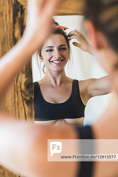 Mirror image of smiling young woman wearing bra