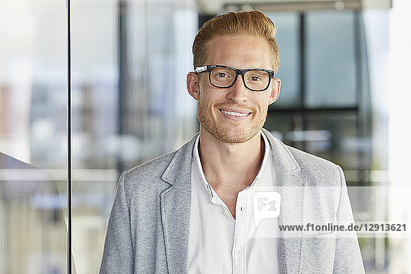Portrait of smiling redheaded businessman wearing glasses