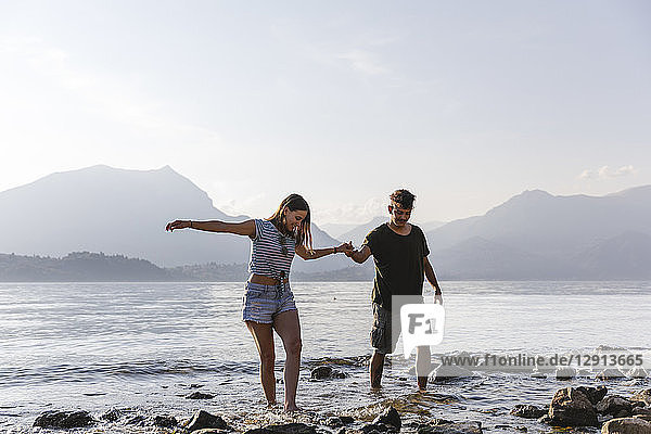 Young couple walking hand in hand at the lakeside