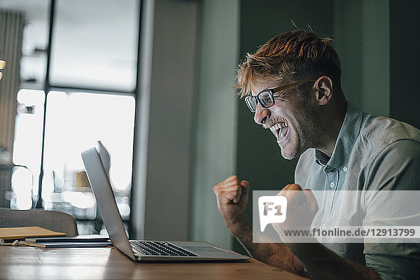 Young man using laptop  laughing happly