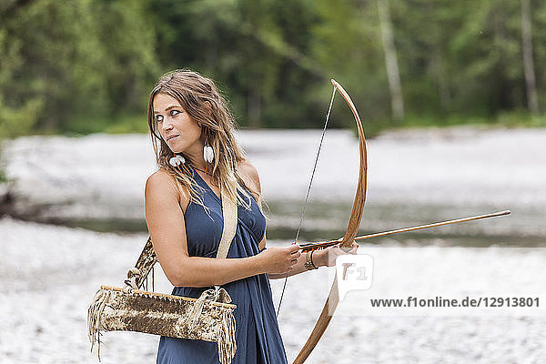 Archeress with bow and arrow in the nature