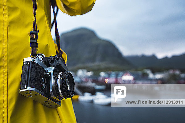 Norway  Lofoten  close-up of man with a camera at a coastal town