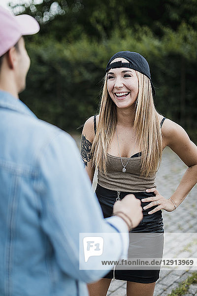 Young woman laughing at man outdoors