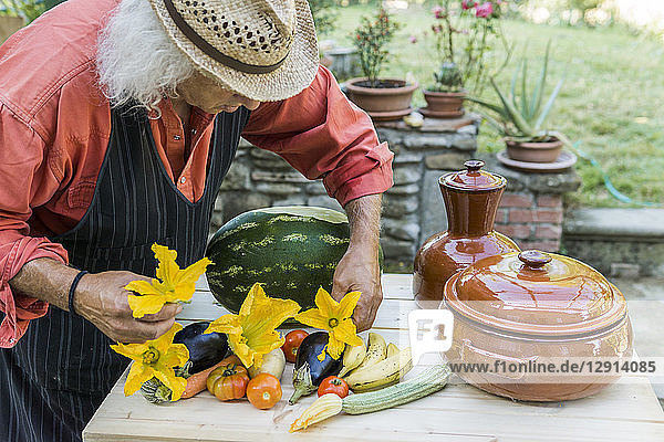 Senior man decorating a table with fruits and vegetables