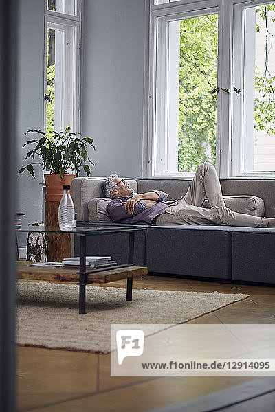 Mature man sleeping on couch at home