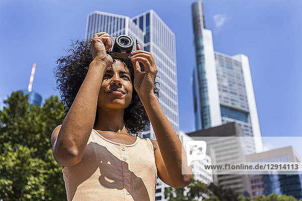 Germany  Frankfurt  portrait of young woman taking photos in the city