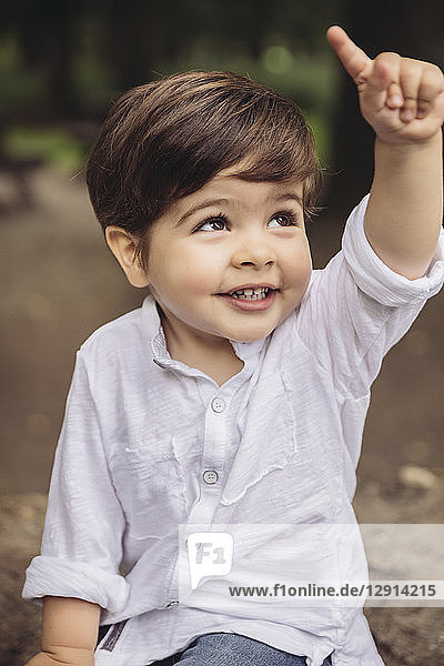 Portrait of smiling toddler raising his finger