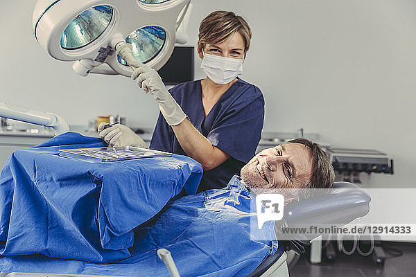 Patient smiling at dental surgeon after successful treatment
