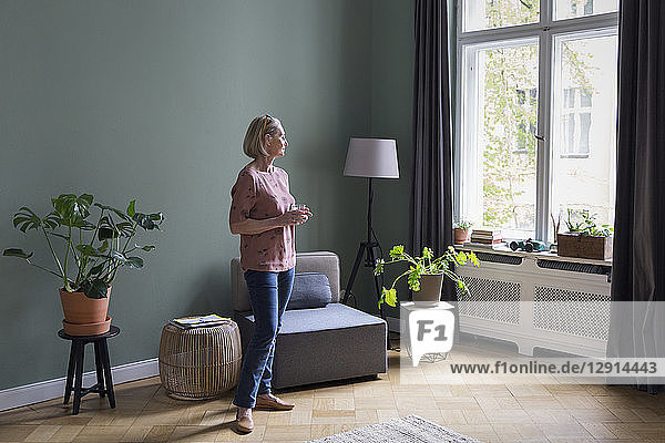 Mature woman at home looking out of window