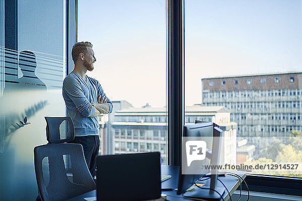 Businessman in office looking out of window