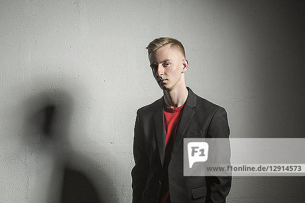 Portrait of serious young man wearing black suit coat and red t-shirt