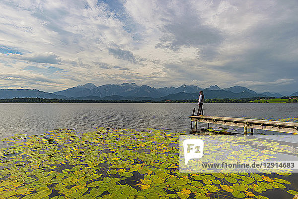 Germany  Bavaria  Allgaeu  Lake Hopfensee  woman standing on jetty