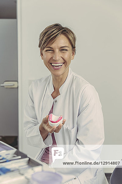 Female dentist holding tooth model