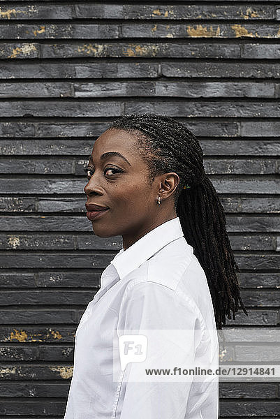 Portrait of smiling businesswoman with dreadlocks wearing white shirt