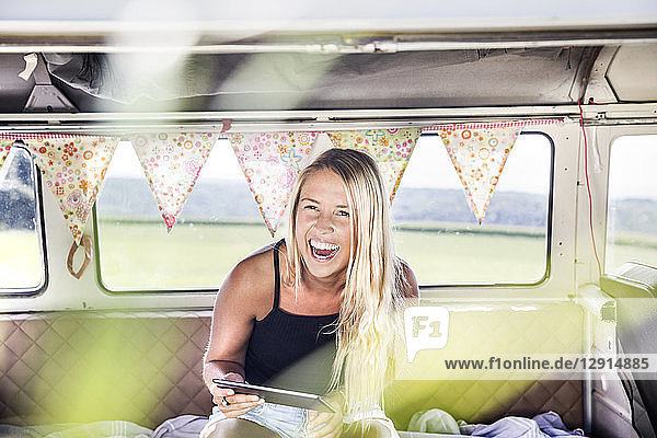 Carefree woman with tablet inside a van