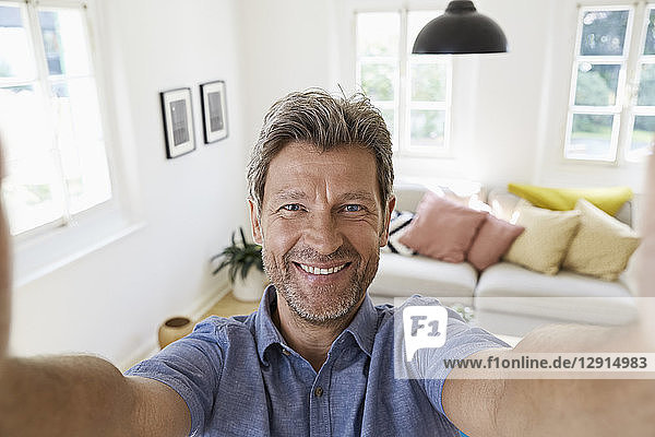 Mature man at home taking a selfie