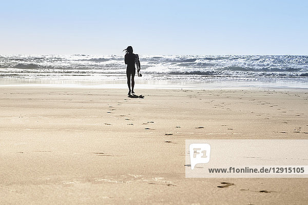 Portugal  Algarve  man on the beach with surfboard