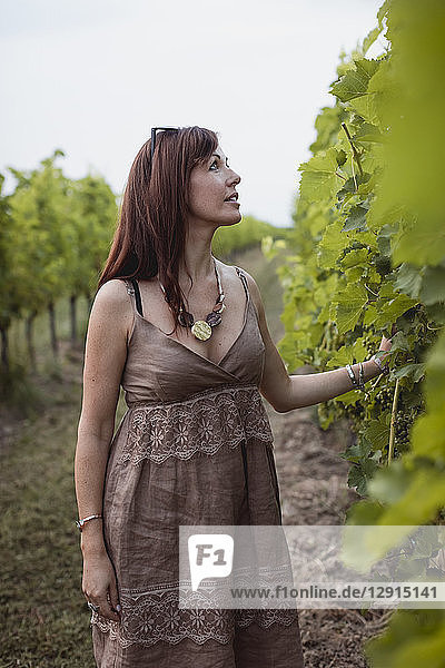 Woman standing in vineyard  wearing summer dress