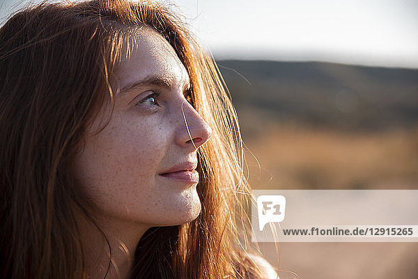 Smiling young woman with freckles looking away