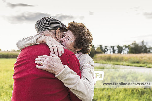 Senior couple hugging in rural landscape