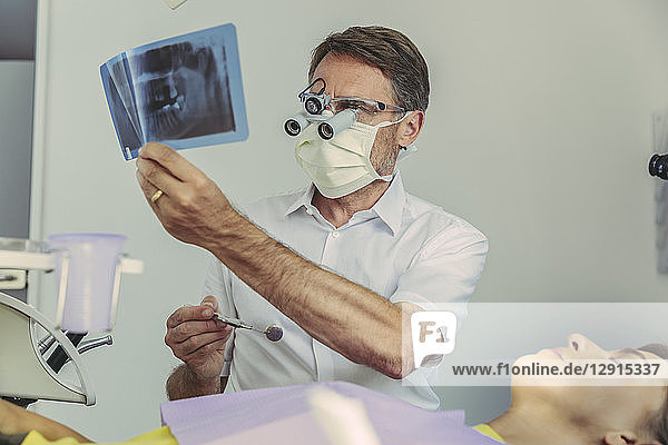 Dentist looking at x-ray image before treatment