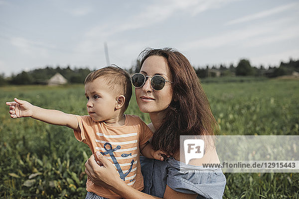 Mother with baby on a field looking at distance