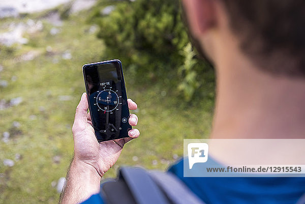 Austria  Tyrol  Hiker using compass app at Lake Seebensee