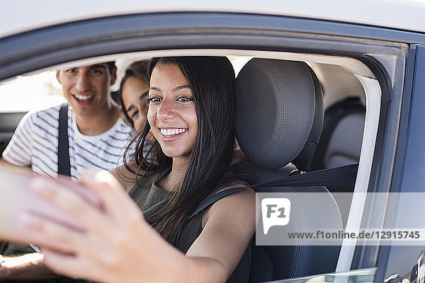 Friends having fun on a road trip  taking smartphone selfies