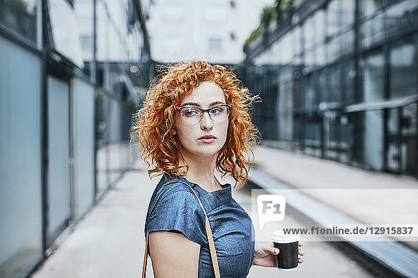 Young businesswoman holding take out coffee