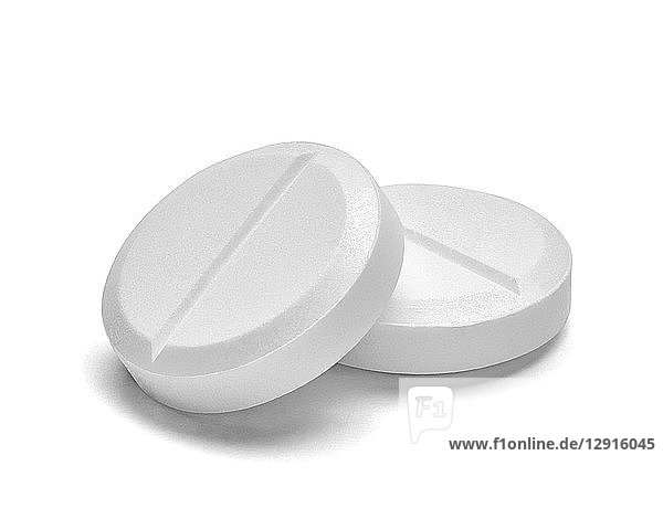 Two white pills on white background  close-up