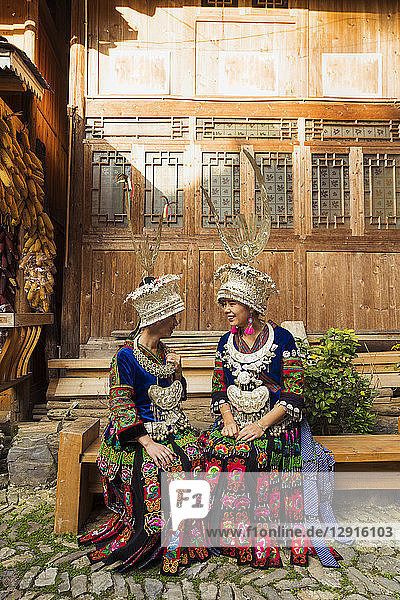 China  Guizhou  two smiling young Miao women wearing traditional dresses and headdresses