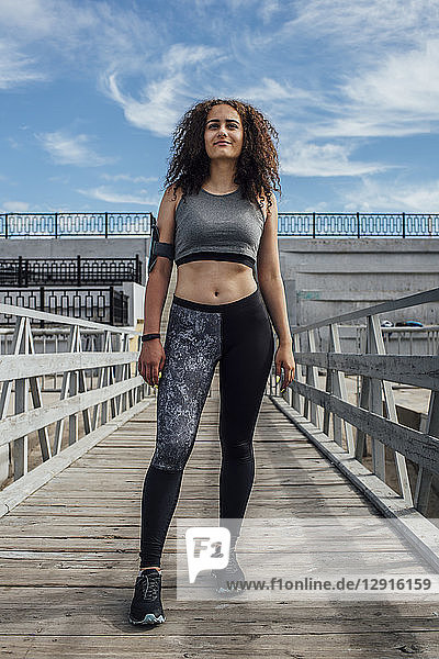 Young athletic woman standing on a pier