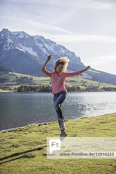 Austria  Tyrol  Walchsee  happy woman jumping at the lake