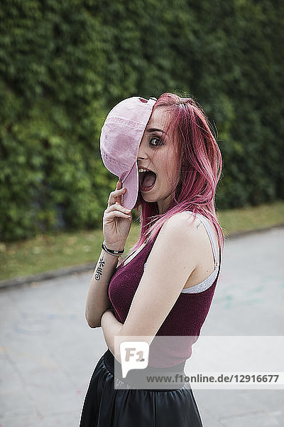 Portrait of cheerful young woman with dyed hair outdoors