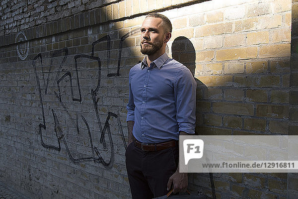 Businessman standing at graffiti wall